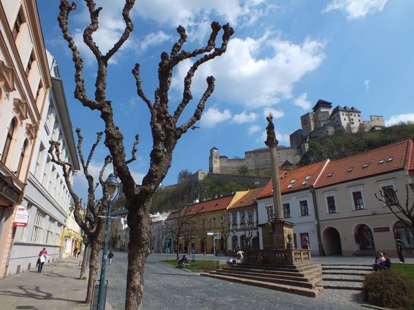 A street in Trenčín; the castle can be seen above the building's roof.